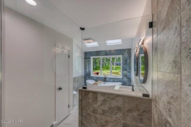 103 Goldrush Dr, Lords Valley, PA 18428 - bathroom with tile walls, marble finish floors, a skylight, a garden tub, and a walk in shower