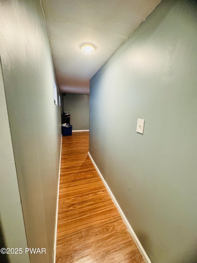 hall featuring light wood finished floors and baseboards