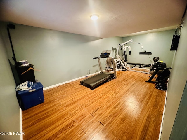 exercise area with baseboards and wood finished floors