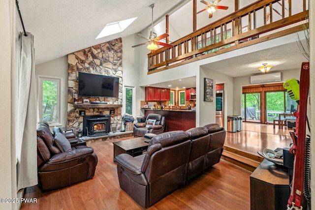 108 Bayberry Ct, East Stroudsburg, PA 18301 - living room with a ceiling fan, a wall mounted AC, wood finished floors, a skylight, and a fireplace
