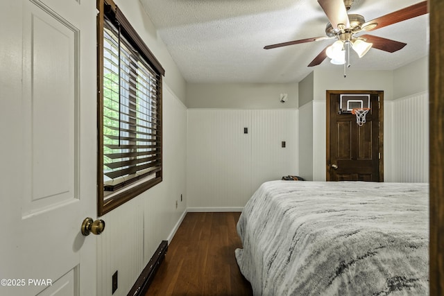 108 Bayberry Ct, East Stroudsburg, PA 18301 - bedroom with dark wood finished floors, a textured ceiling, baseboards, a ceiling fan, and wainscoting