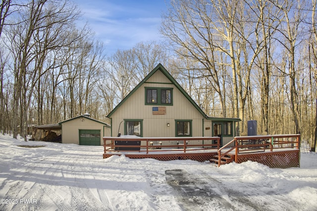 view of front of property featuring a garage, a deck, and an outdoor structure