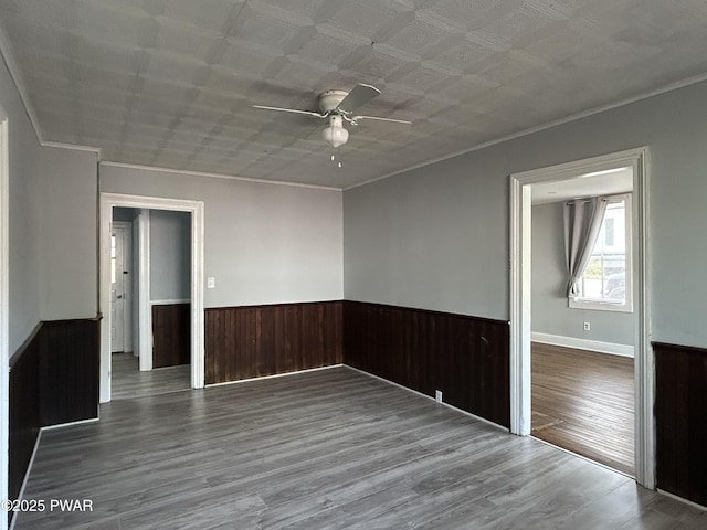 887 Maple Ave, Honesdale, PA 18431 - unfurnished room featuring wood finished floors, a ceiling fan, crown molding, wainscoting, and wooden walls
