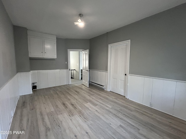 887 Maple Ave, Honesdale, PA 18431 - interior space featuring a wainscoted wall, light wood-style floors, and a baseboard heating unit