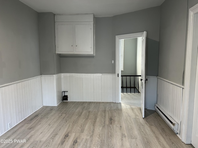 887 Maple Ave, Honesdale, PA 18431 - interior space with baseboard heating, light wood-style flooring, and a wainscoted wall