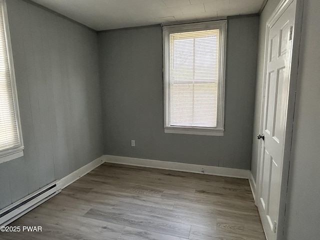 887 Maple Ave, Honesdale, PA 18431 - empty room with a baseboard heating unit, a wealth of natural light, and wood finished floors