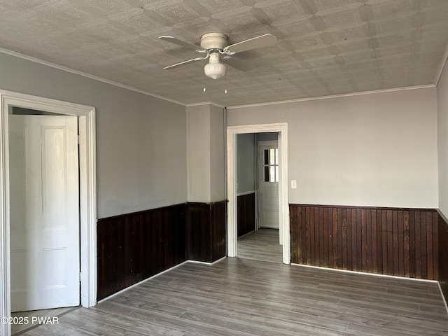 887 Maple Ave, Honesdale, PA 18431 - spare room with a ceiling fan, ornamental molding, a wainscoted wall, and wood finished floors