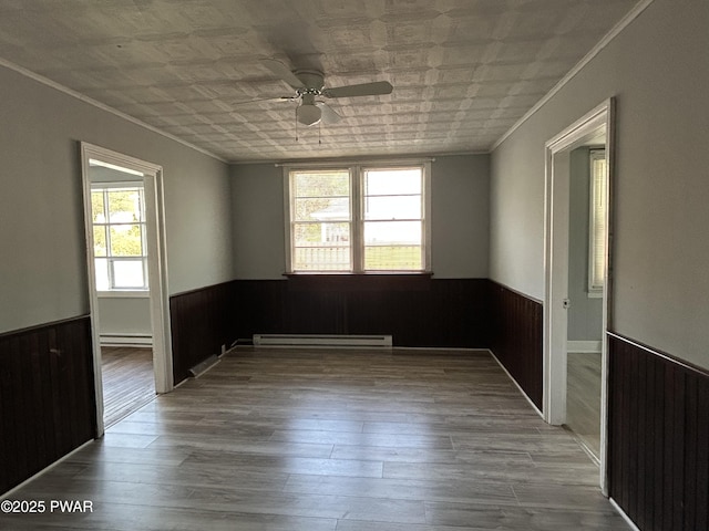 887 Maple Ave, Honesdale, PA 18431 - empty room featuring a baseboard radiator, wooden walls, and a wainscoted wall