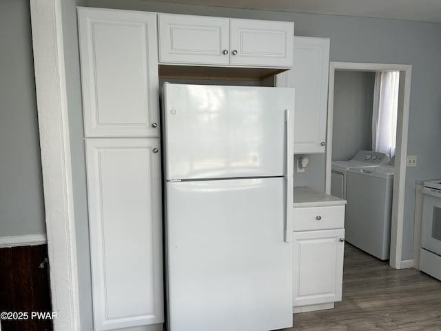 887 Maple Ave, Honesdale, PA 18431 - kitchen with white cabinets, washing machine and dryer, light wood-type flooring, and white appliances