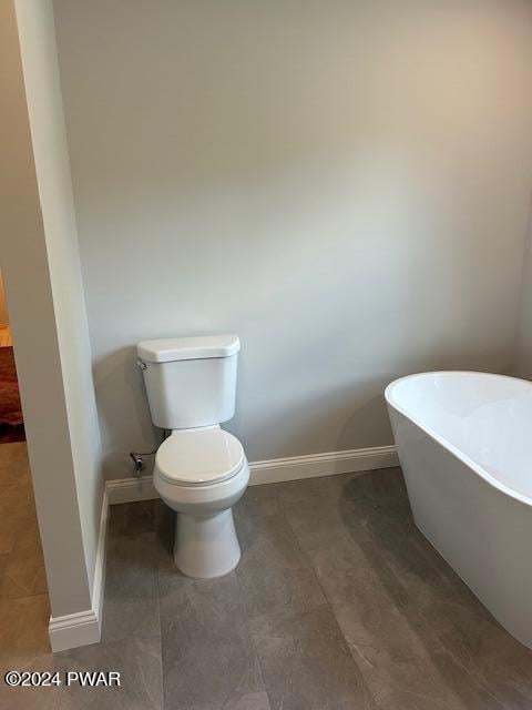 bathroom featuring a tub to relax in and toilet