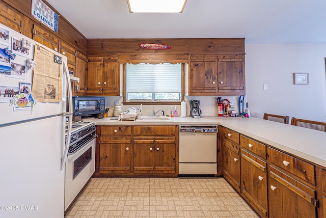 511 Overlook Ter, Stroudsburg, PA 18360 - kitchen with white appliances, light countertops, brown cabinets, and a peninsula