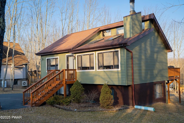 view of front of home with a shingled roof and a chimney