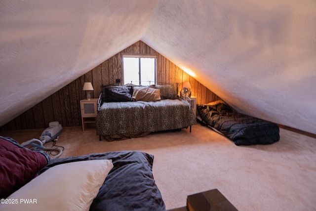 carpeted bedroom featuring lofted ceiling, wooden walls, and a textured ceiling