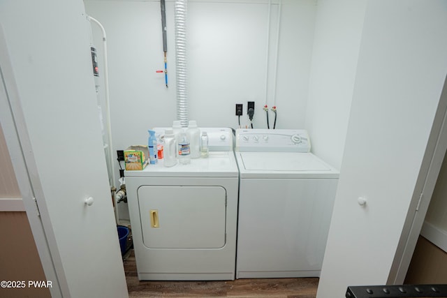 laundry area featuring laundry area, wood finished floors, and washing machine and clothes dryer