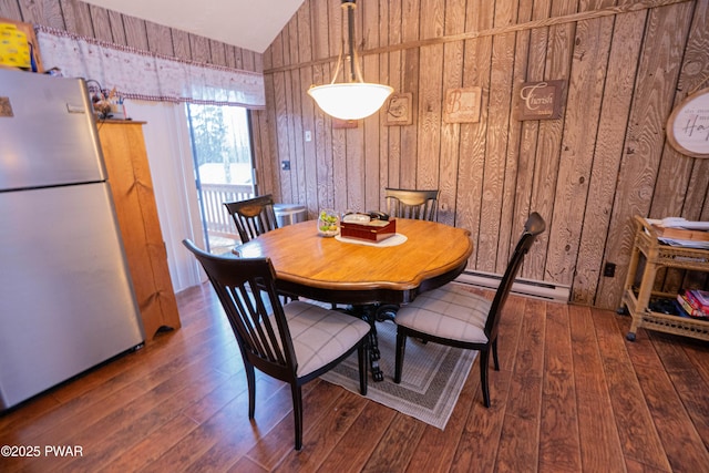 dining area featuring wooden walls, vaulted ceiling, and hardwood / wood-style floors