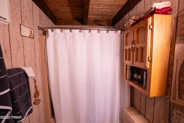 full bathroom featuring a shower with curtain, wooden ceiling, beamed ceiling, and wooden walls