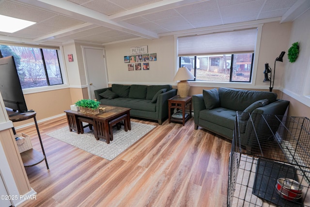 living area with light wood-type flooring and a paneled ceiling