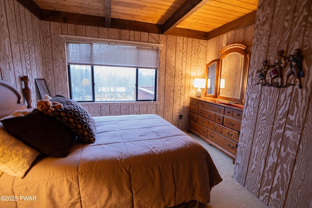 bedroom featuring beam ceiling, carpet flooring, wood walls, and wooden ceiling