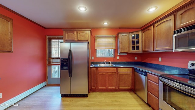 kitchen with sink, stainless steel appliances, a baseboard radiator, light hardwood / wood-style flooring, and ornamental molding