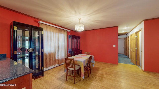 dining area featuring a notable chandelier, light hardwood / wood-style floors, crown molding, and a baseboard radiator