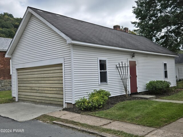 view of side of property featuring a garage and an outbuilding