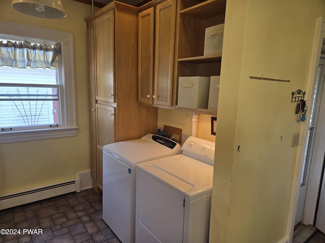 washroom featuring cabinets, washing machine and dryer, and a baseboard heating unit