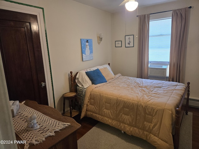 bedroom featuring multiple windows, dark wood-type flooring, ceiling fan, and cooling unit