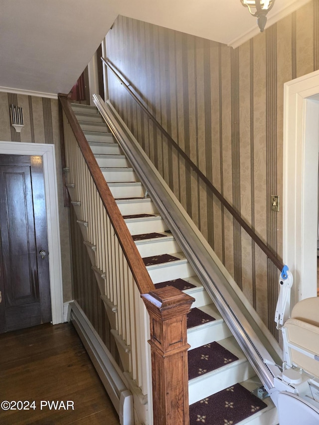 stairs featuring hardwood / wood-style floors and ornamental molding