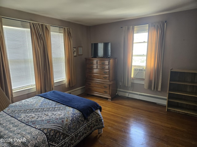 bedroom with cooling unit, baseboard heating, and dark wood-type flooring