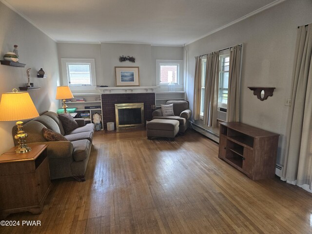 living area with a brick fireplace, a baseboard radiator, and wood-type flooring