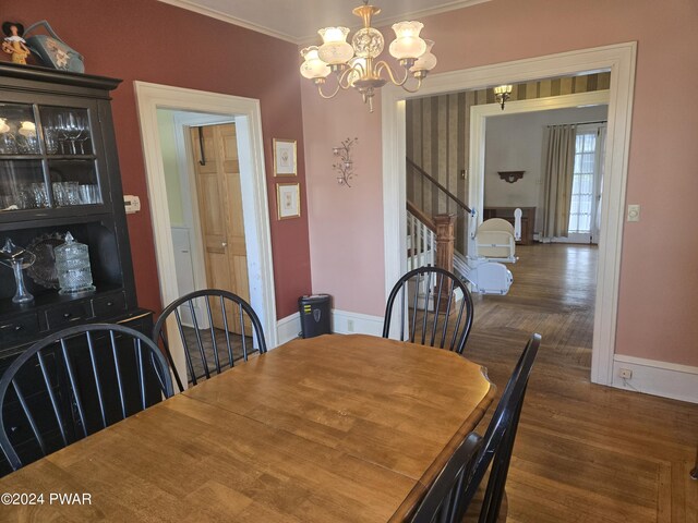 dining room featuring crown molding, a chandelier, and dark hardwood / wood-style floors