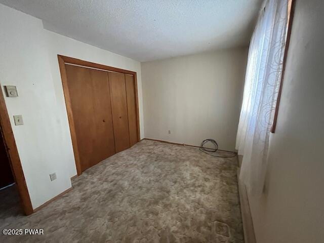 unfurnished bedroom with a closet, a textured ceiling, and carpet