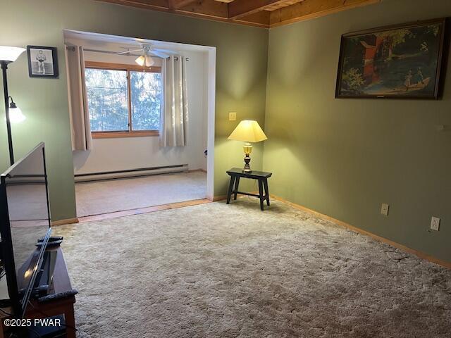 unfurnished room with ceiling fan, a baseboard radiator, and carpet