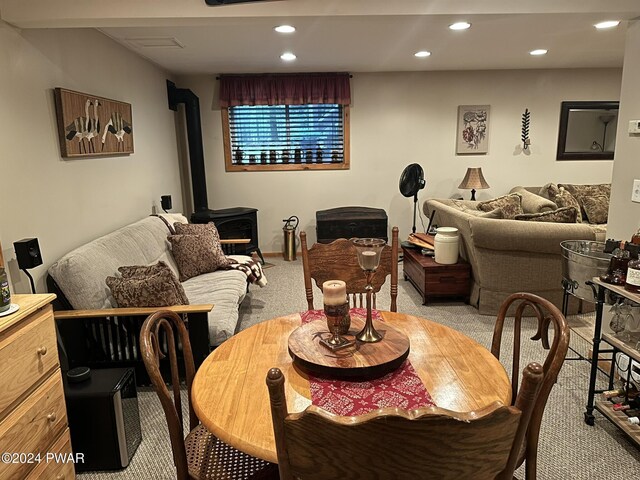 dining area featuring a wood stove and light carpet