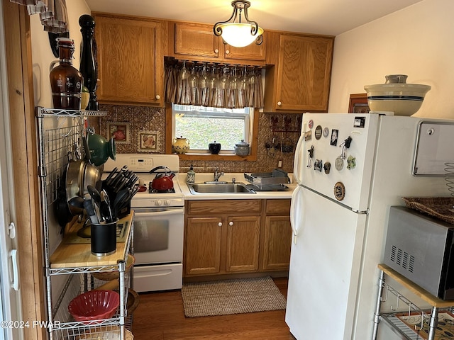 kitchen featuring dark hardwood / wood-style flooring, white appliances, tasteful backsplash, and sink