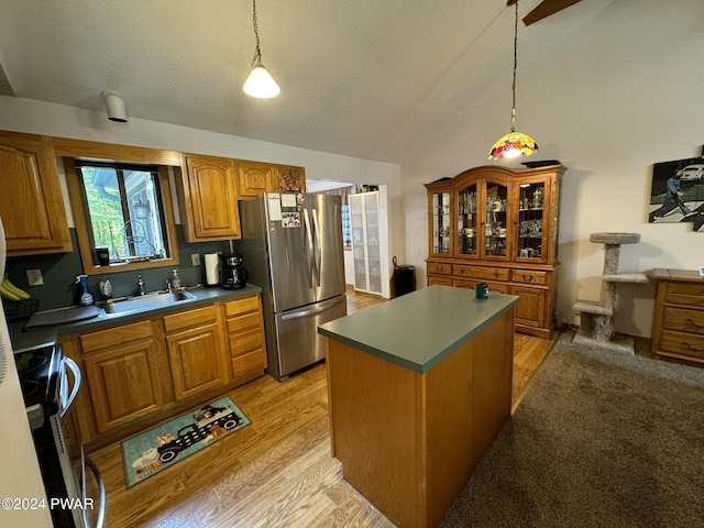 kitchen with stove, sink, a center island, light hardwood / wood-style floors, and stainless steel refrigerator