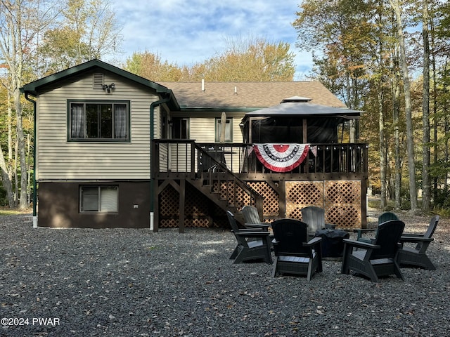 rear view of property with a gazebo and a deck