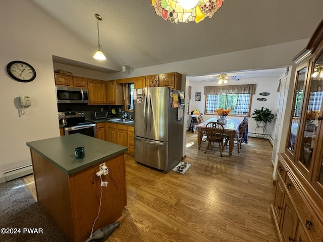 kitchen featuring hardwood / wood-style floors, a center island, sink, ceiling fan, and stainless steel appliances