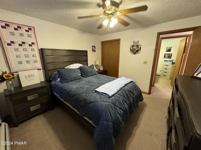 bedroom with a textured ceiling, ceiling fan, and light carpet