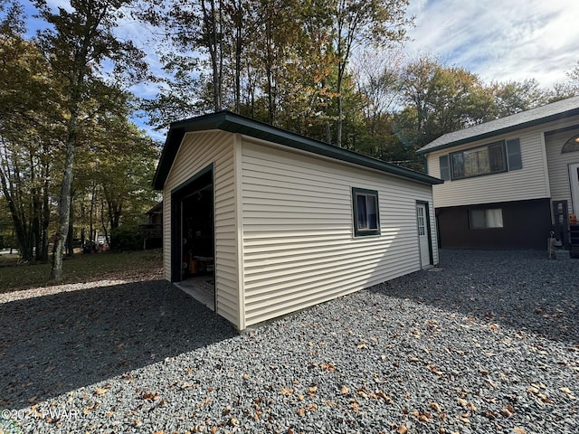 view of home's exterior with a garage and an outbuilding