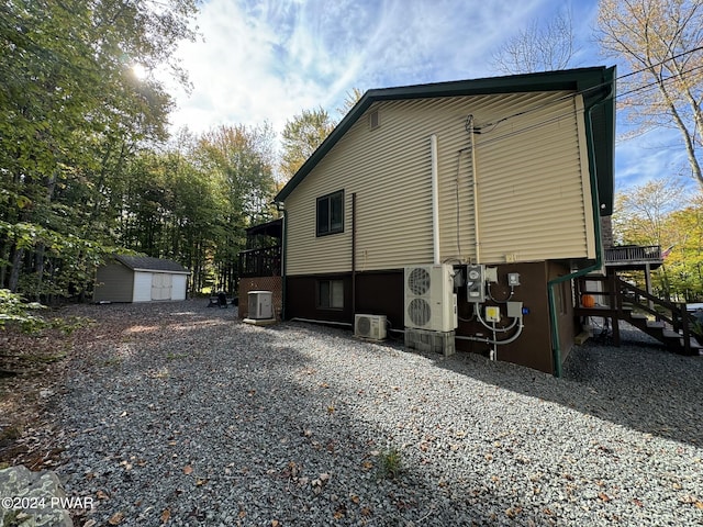 view of home's exterior with a storage unit, central air condition unit, and ac unit