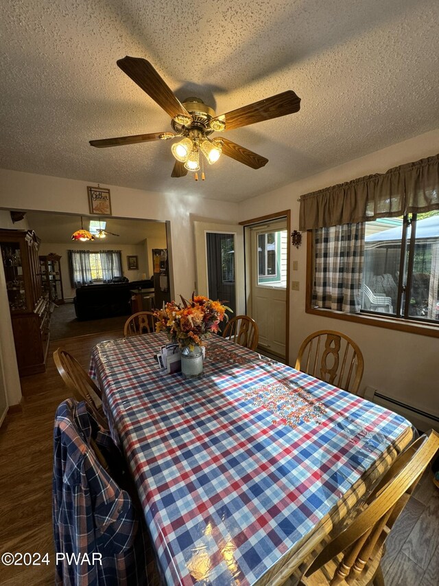 dining room featuring hardwood / wood-style floors, ceiling fan, a textured ceiling, and a baseboard heating unit