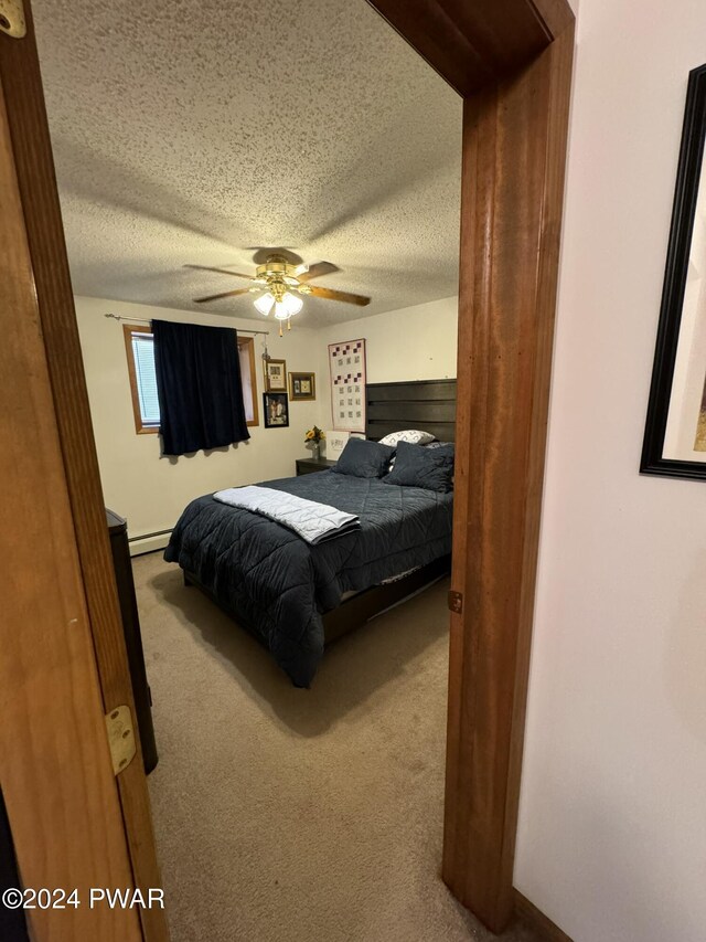 carpeted bedroom with a textured ceiling, baseboard heating, and ceiling fan