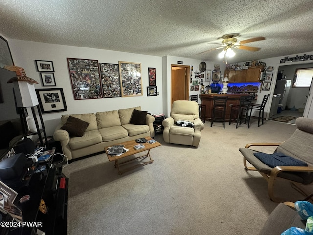 living room with bar, a textured ceiling, carpet floors, and ceiling fan