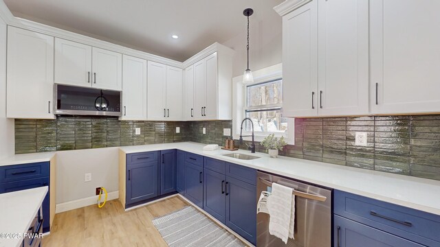 kitchen featuring blue cabinets, sink, white cabinetry, pendant lighting, and stainless steel appliances