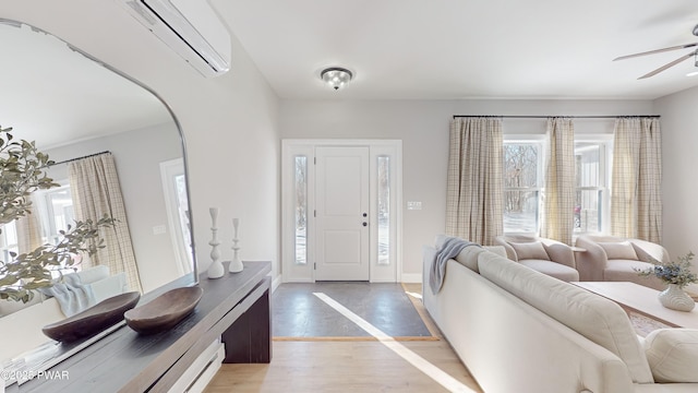 living room with ceiling fan, plenty of natural light, hardwood / wood-style floors, and a wall unit AC