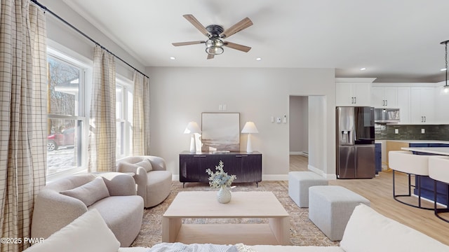 living room with ceiling fan and light wood-type flooring