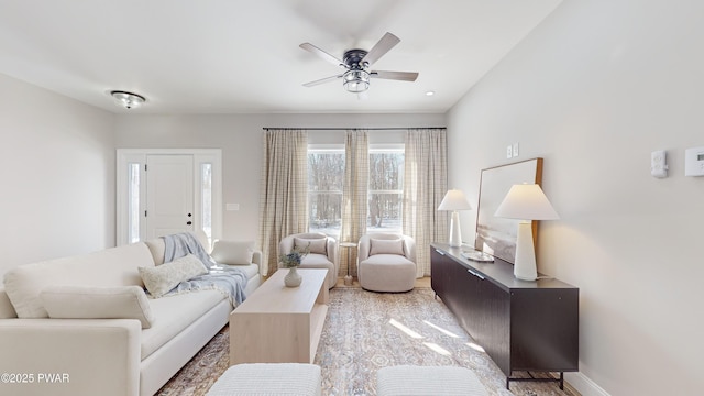 living room featuring baseboards and a ceiling fan