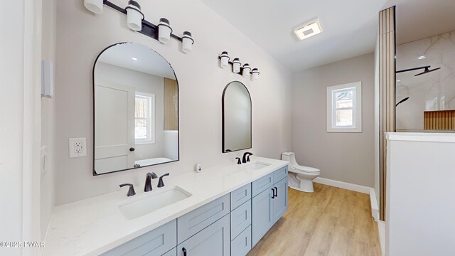 bedroom with ceiling fan, light hardwood / wood-style floors, ensuite bath, and an AC wall unit