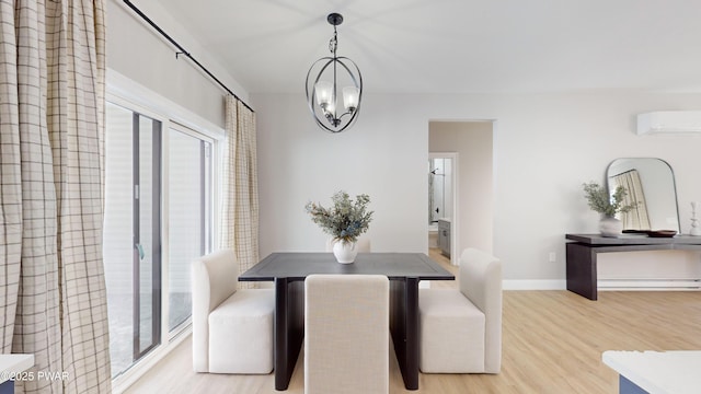 dining area with an inviting chandelier, light hardwood / wood-style flooring, a wall mounted AC, and baseboard heating